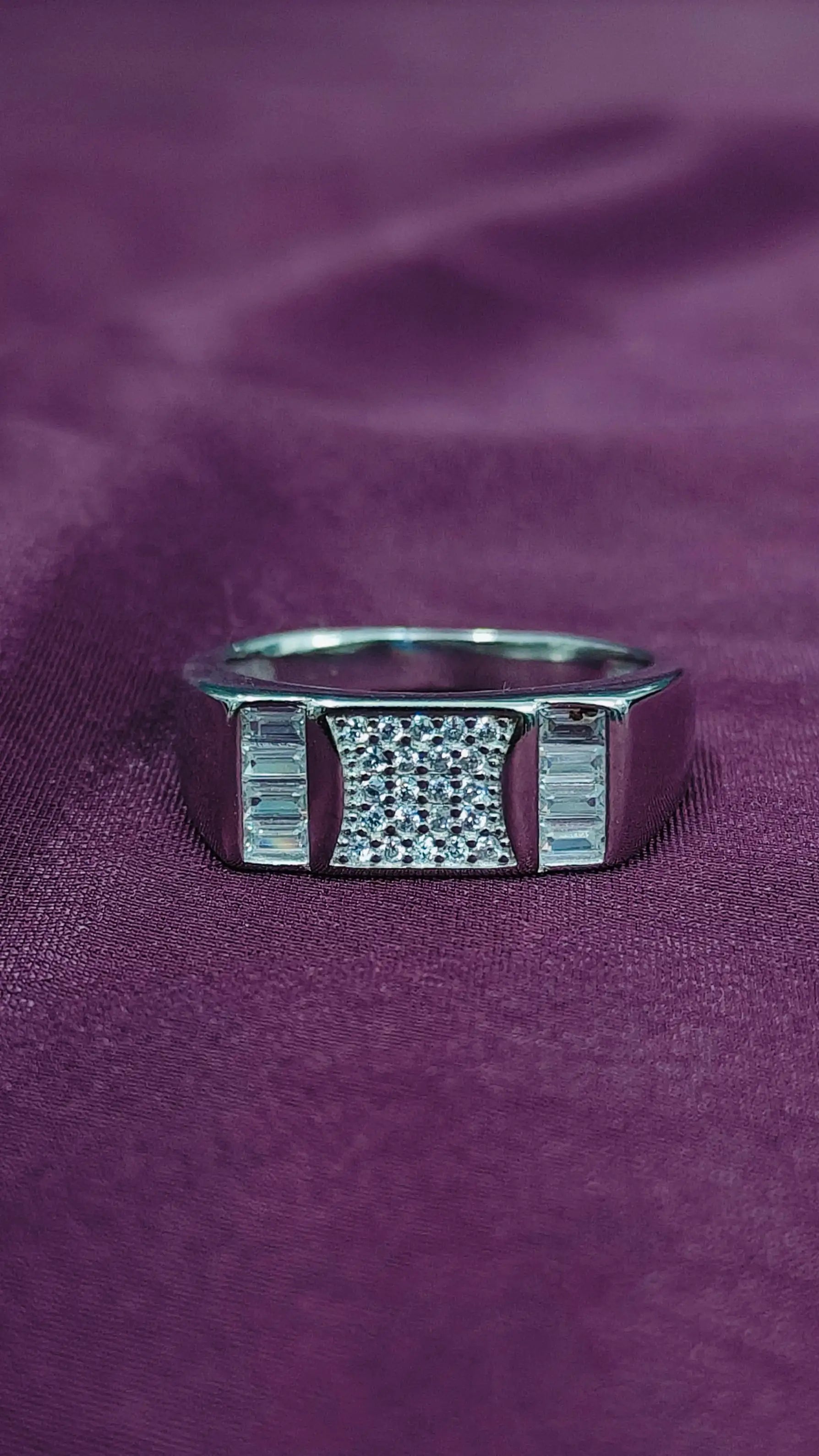 Silver ring with gemstones on a purple fabric background