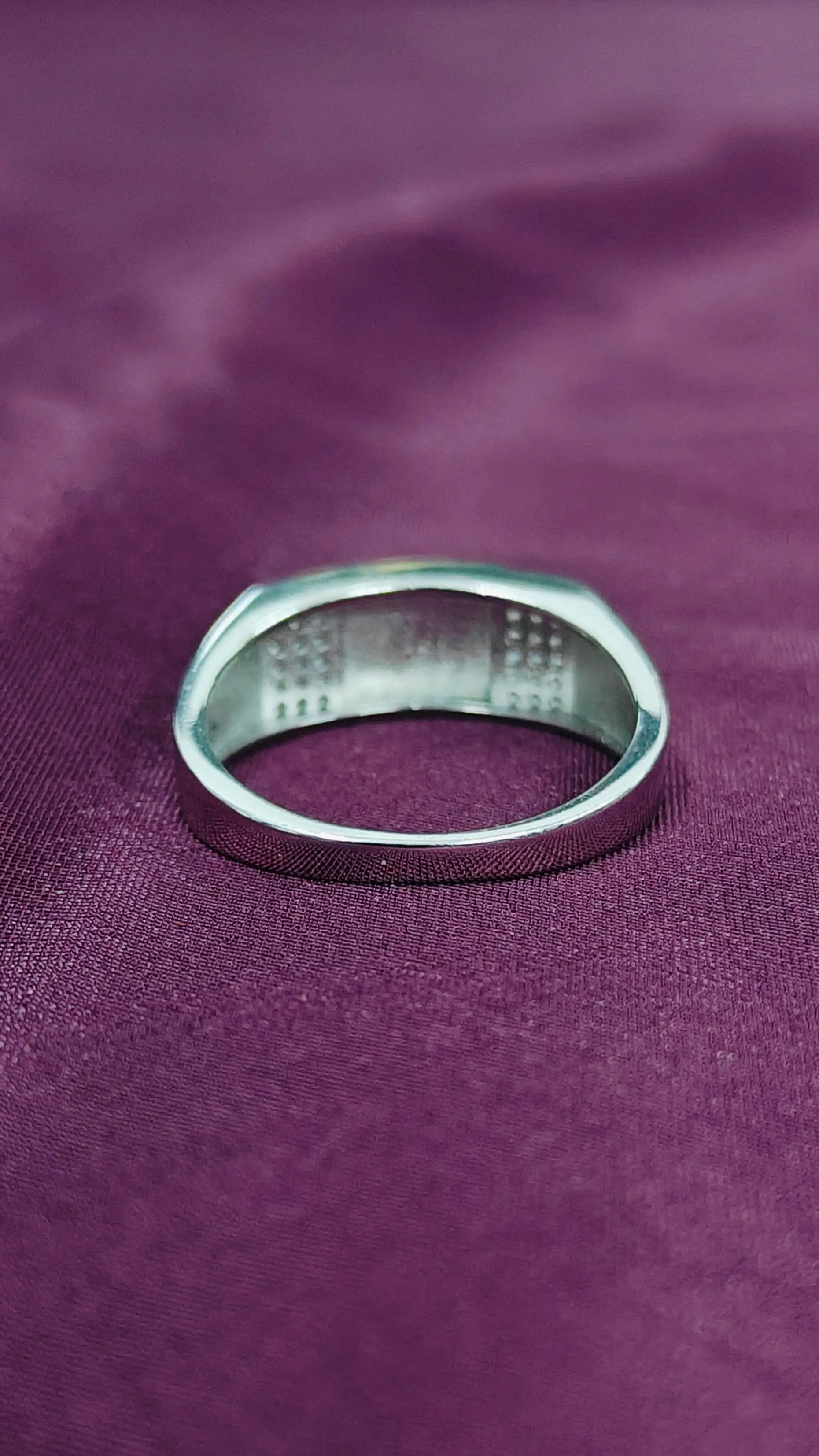 Silver ring on a purple fabric background