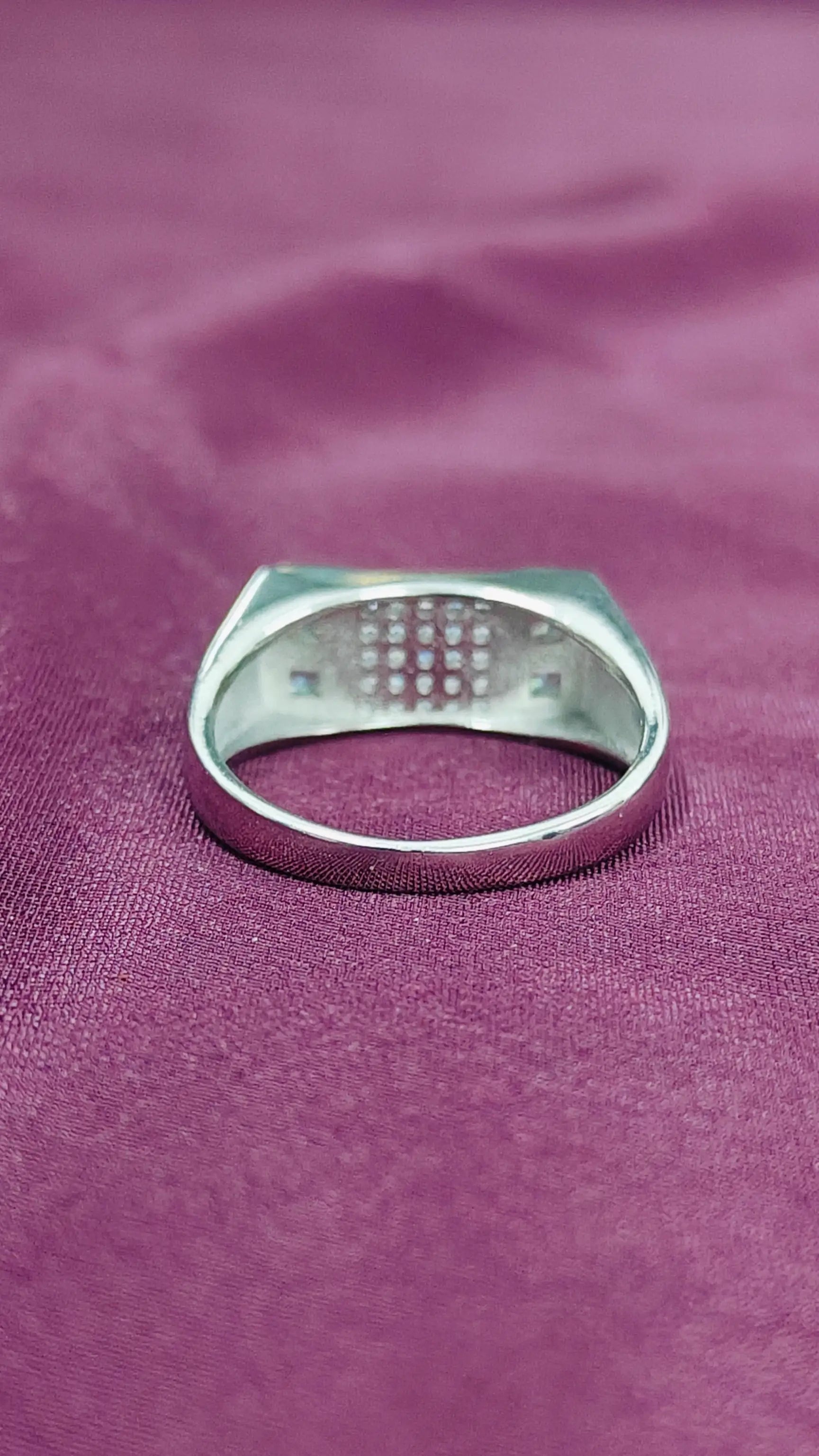 Silver ring on a purple fabric background