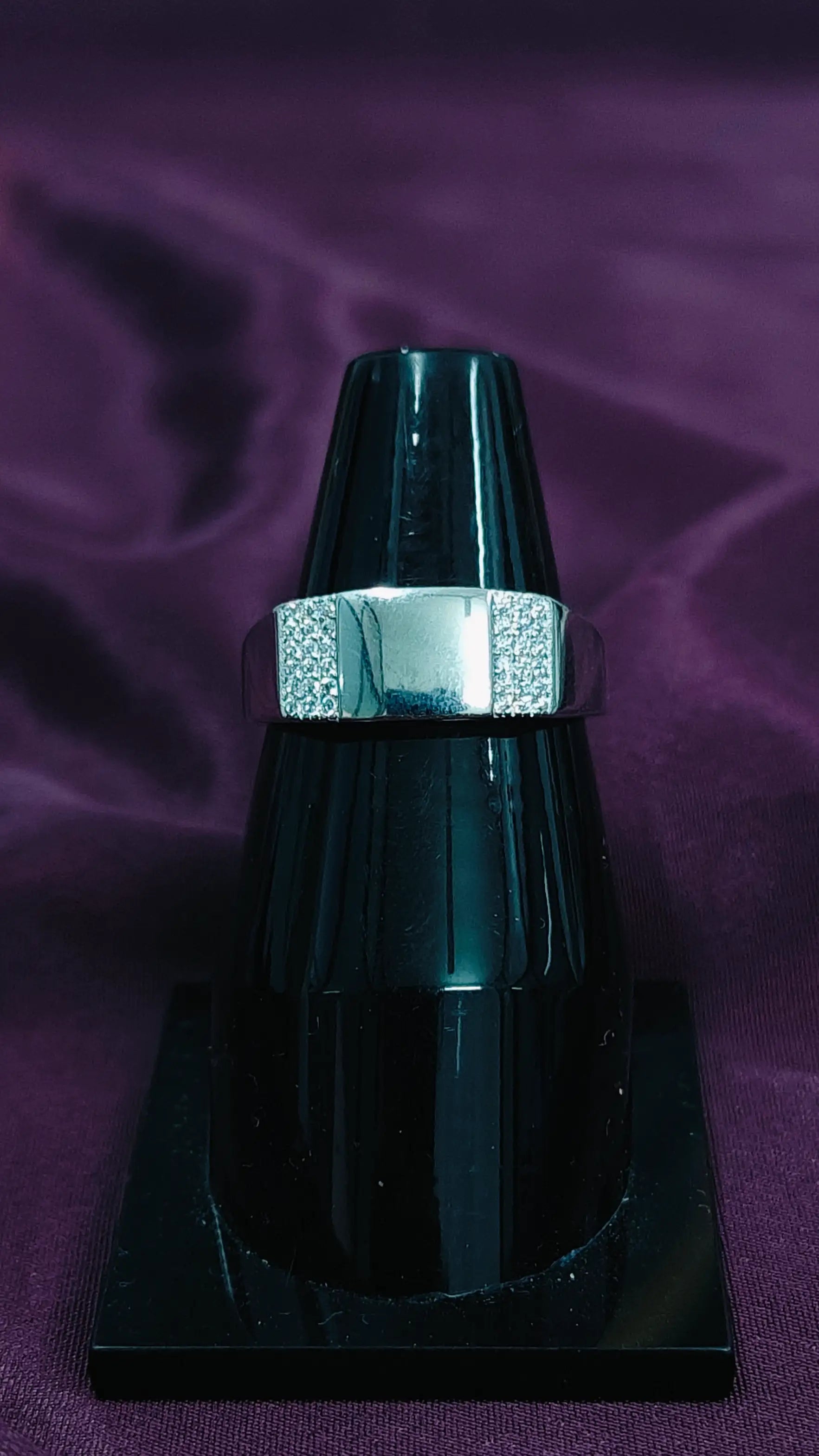 Black and silver object on a purple fabric background