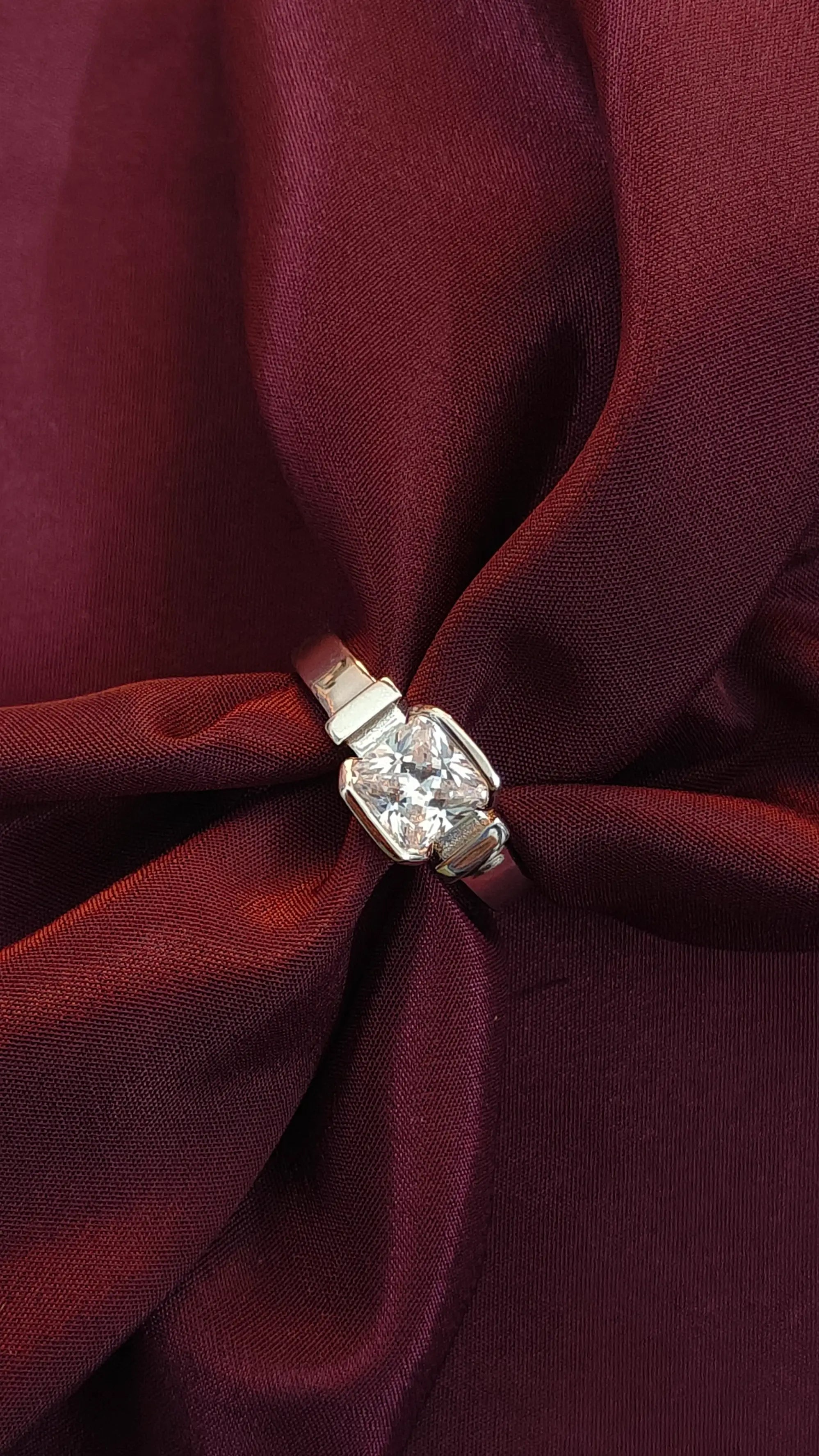 Diamond ring on a burgundy fabric background