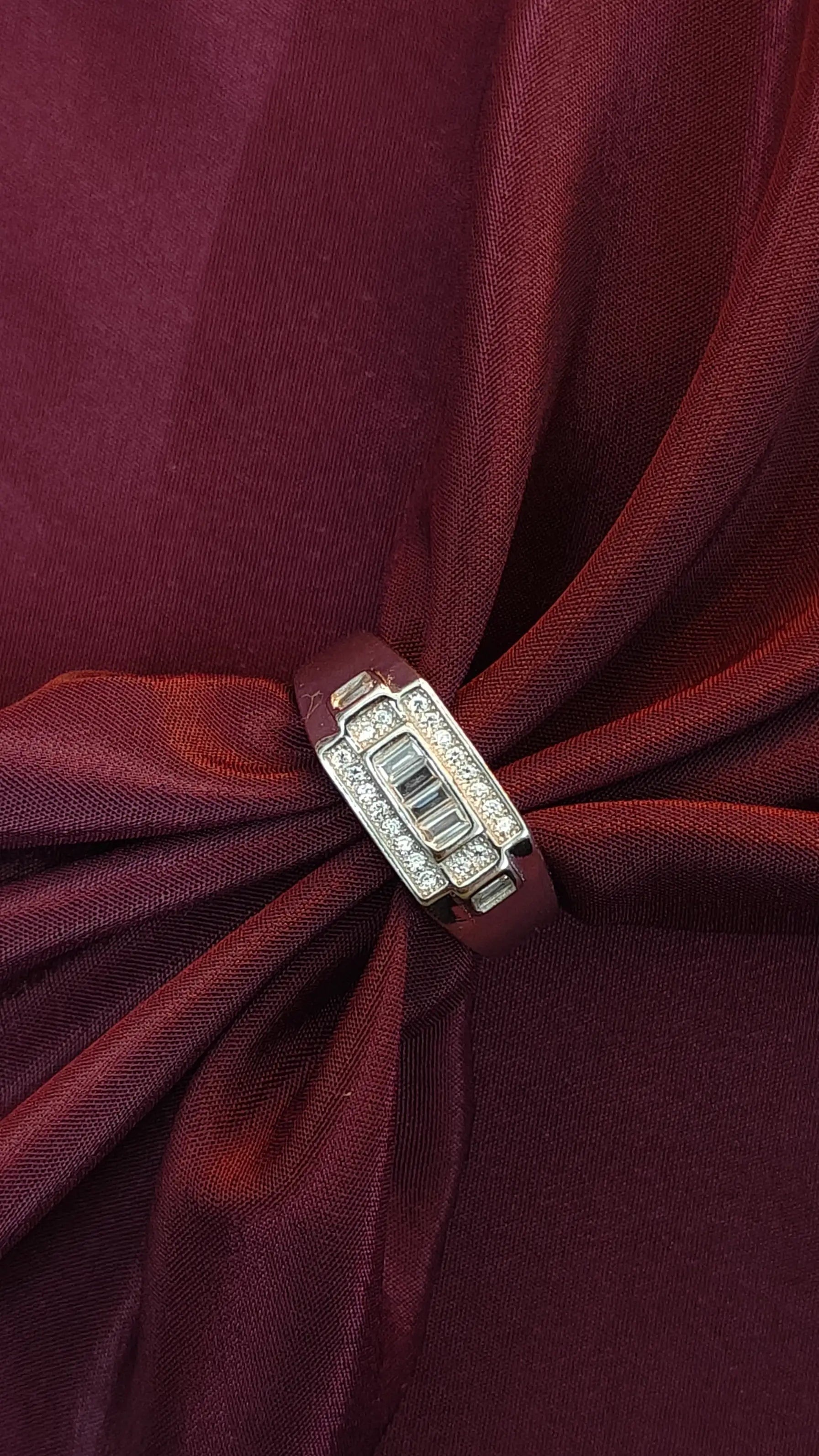 Close-up of a red fabric bow with a decorative clasp