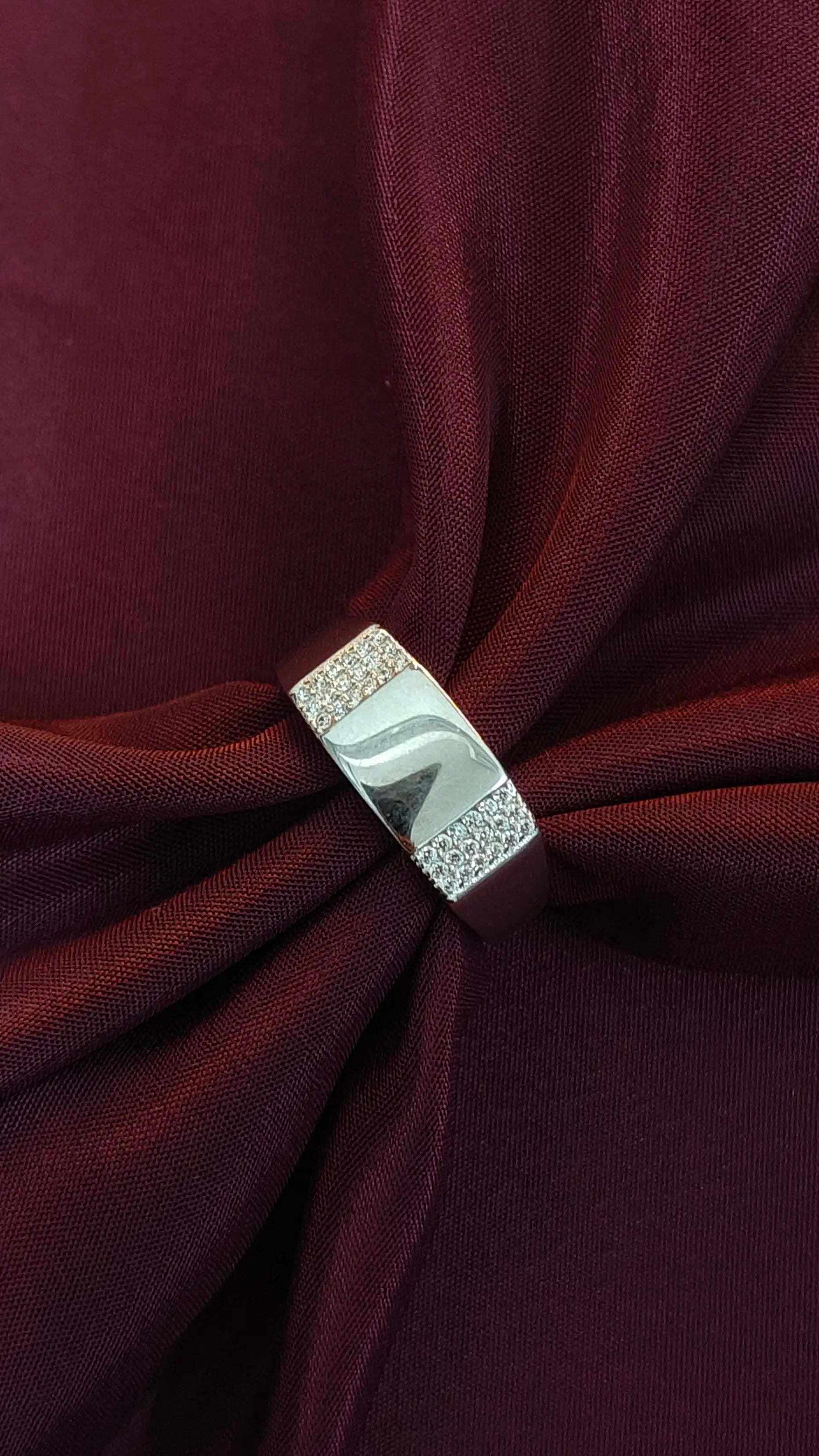 Close-up of a burgundy fabric with a silver brooch
