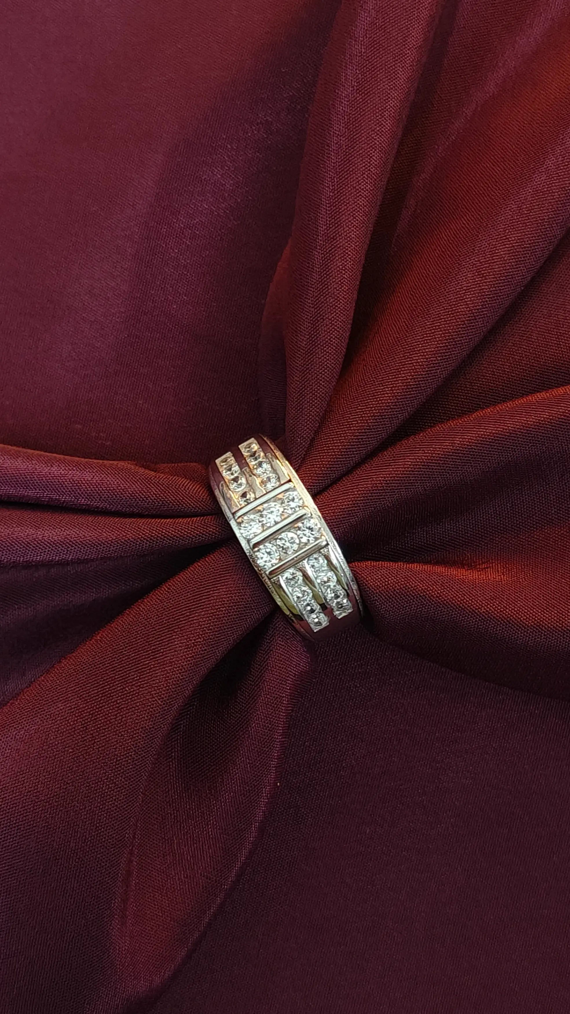 Gold ring with diamonds on a red fabric background