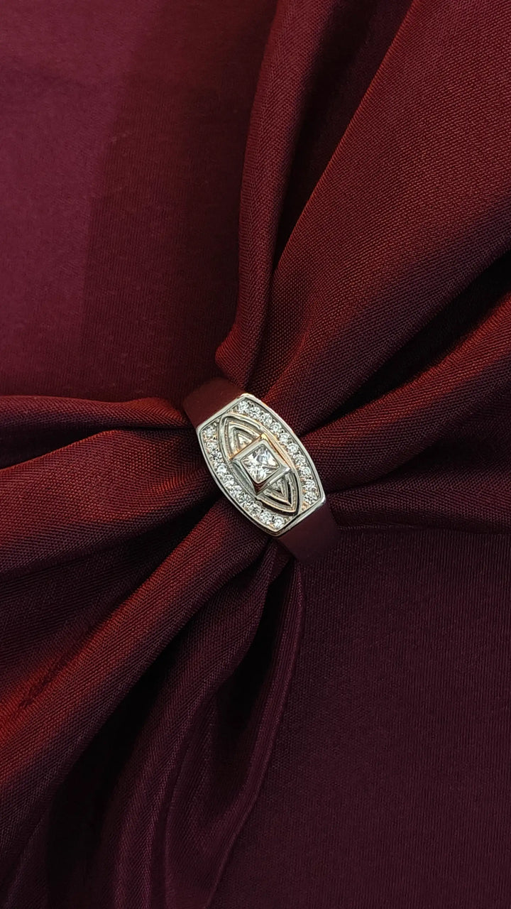 Close-up of a burgundy fabric with a decorative brooch featuring a diamond.