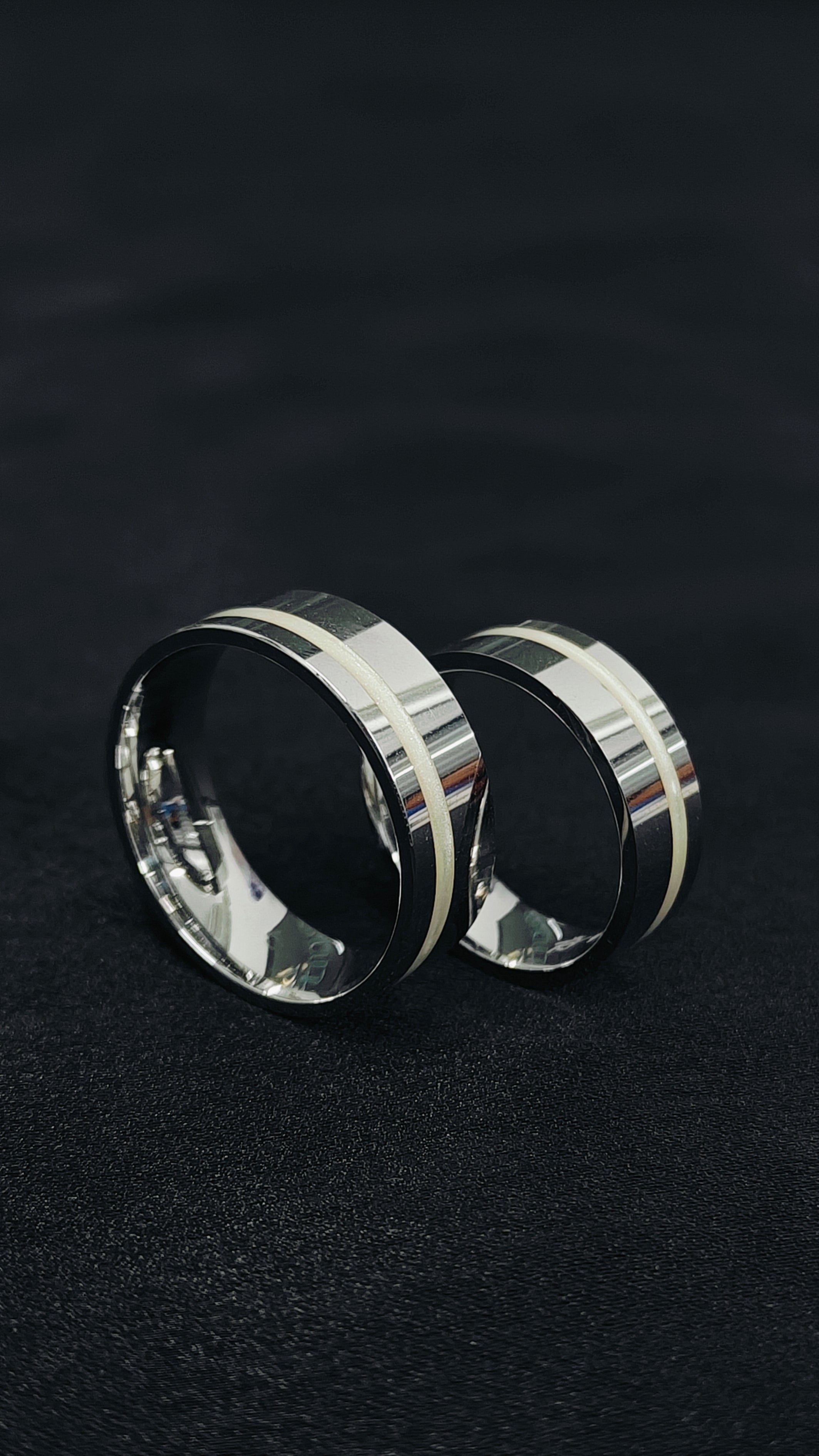 Two silver rings on a black background