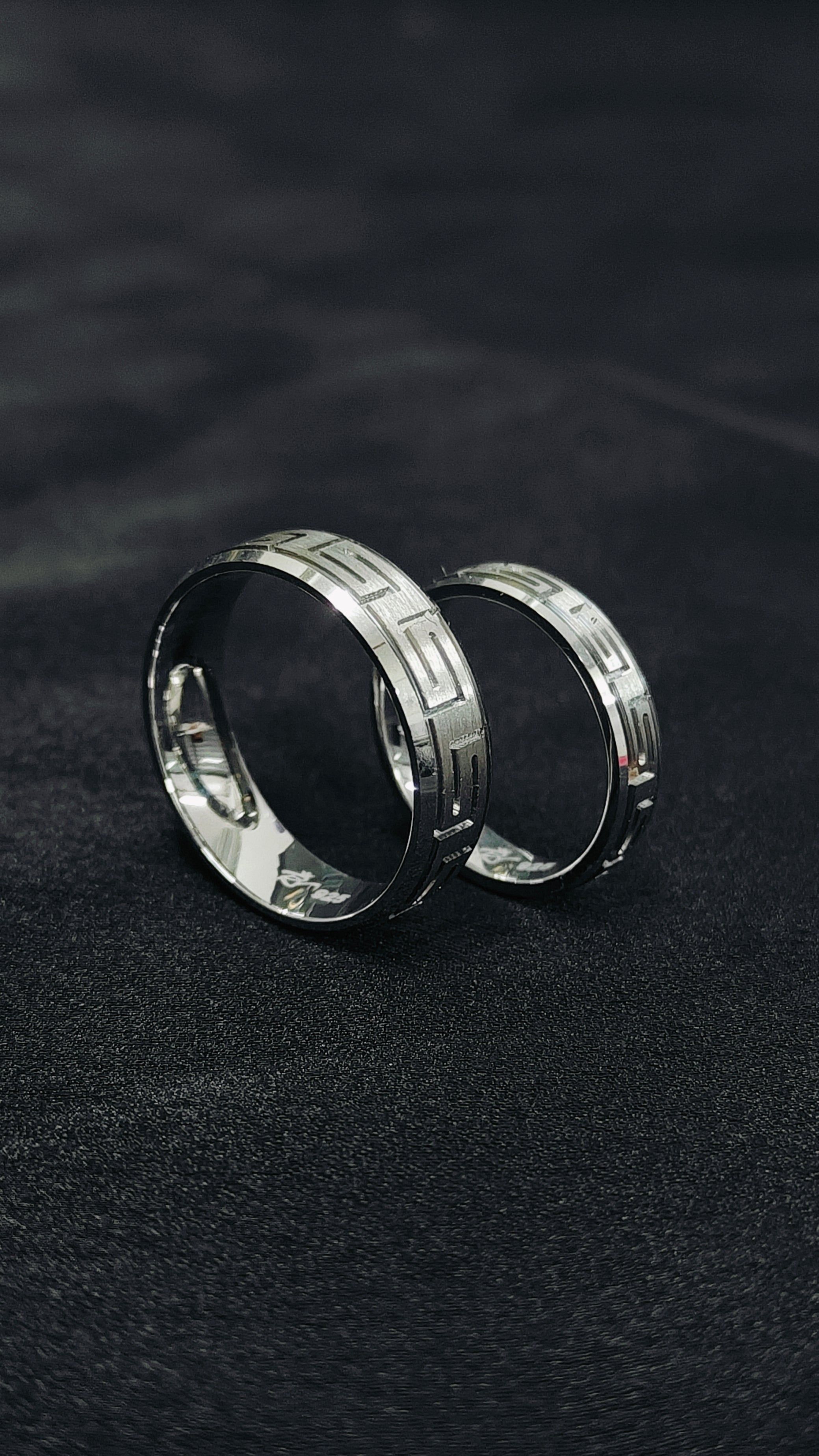 Pair of silver hoop earrings on a dark textured background