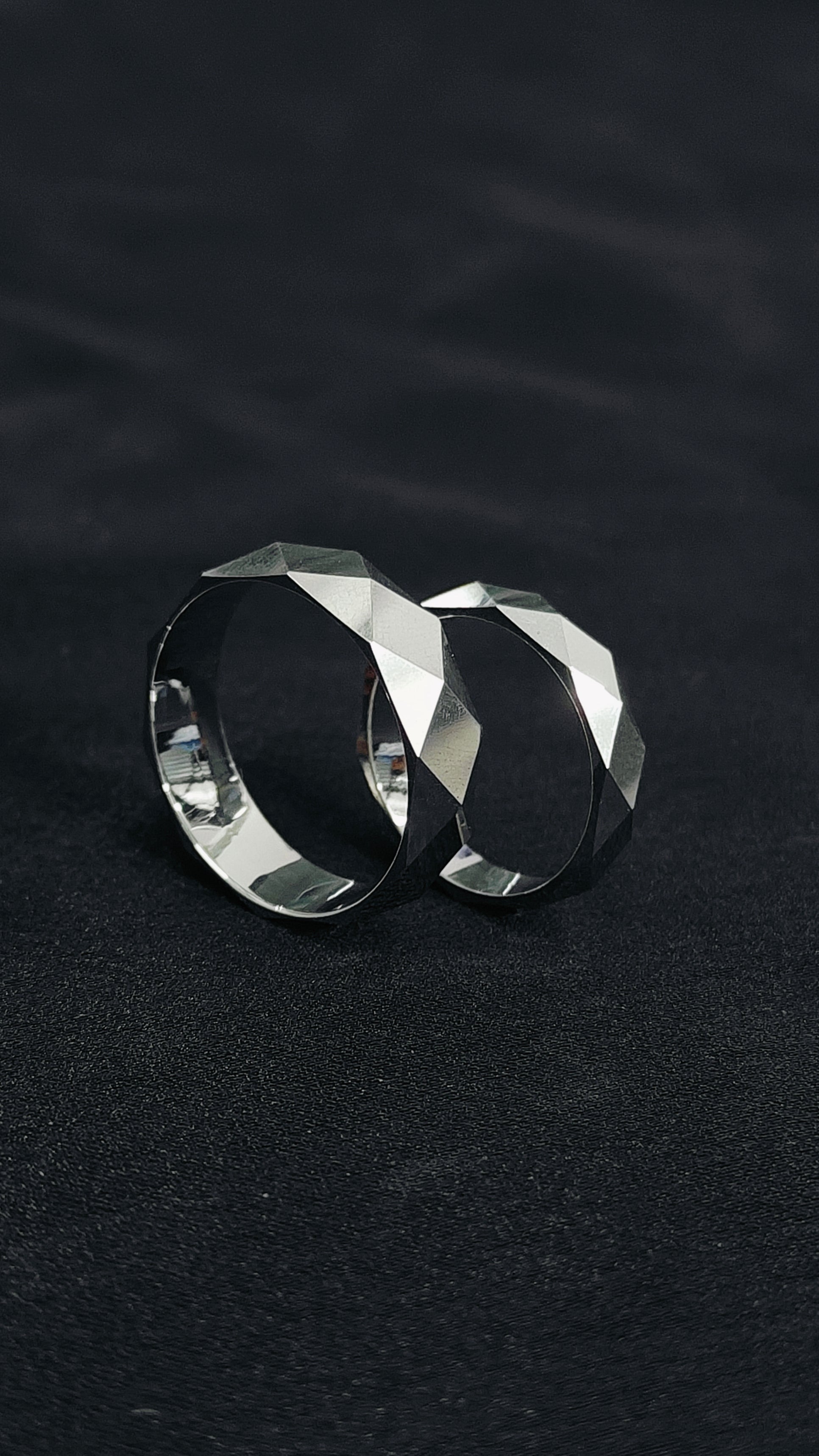 Two silver hoop earrings on a black background