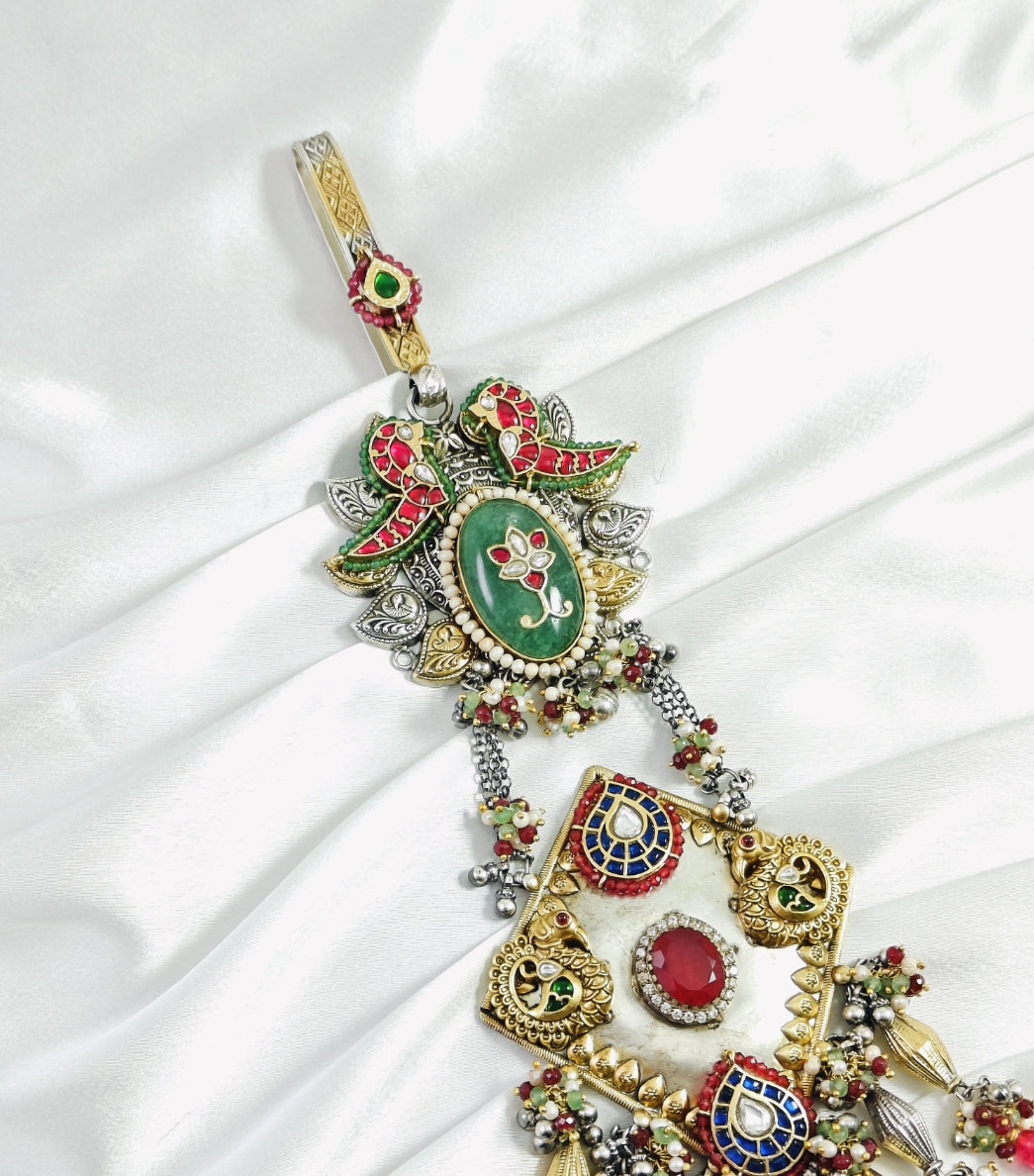 Decorative pendant with intricate designs on a white fabric background