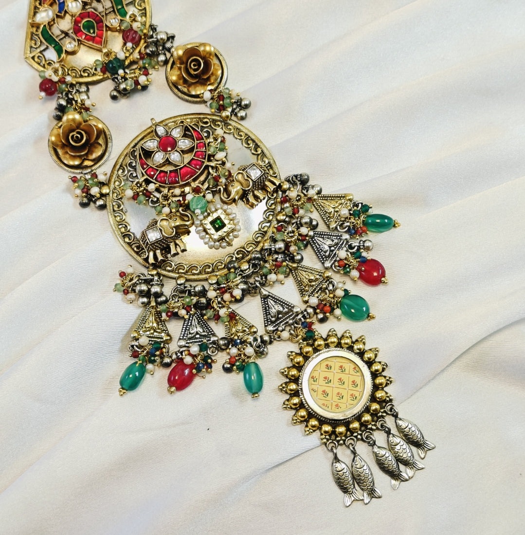 Decorative necklace with colorful beads and intricate designs on a white fabric background