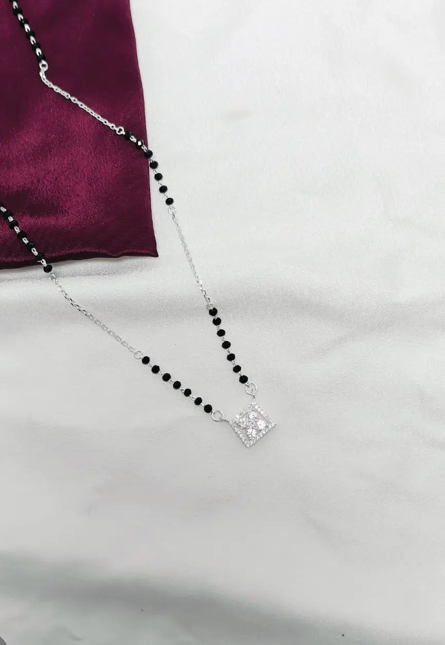 Necklace with black beads and a silver clasp on a white background