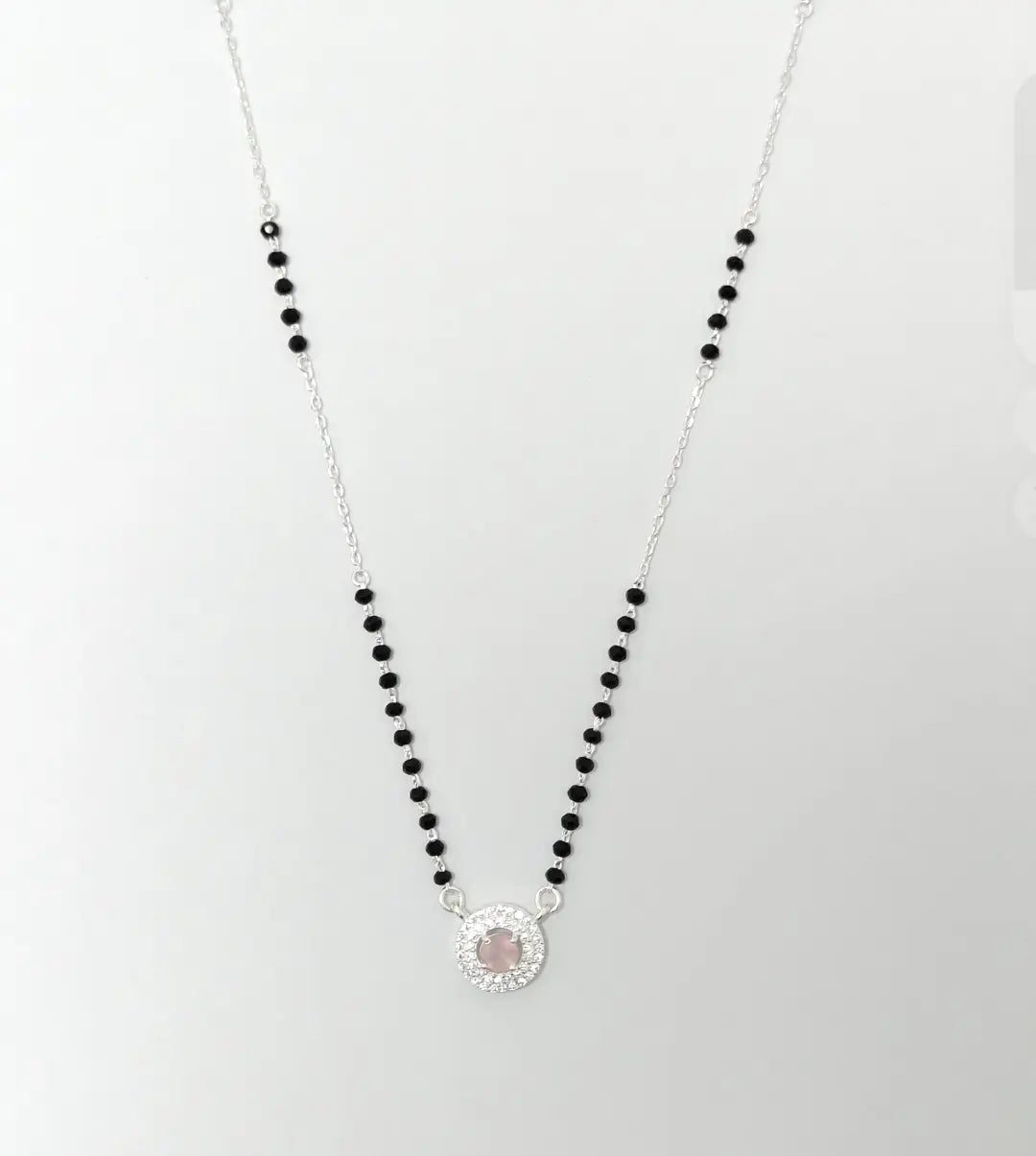Necklace with black beads and a silver clasp on a white background