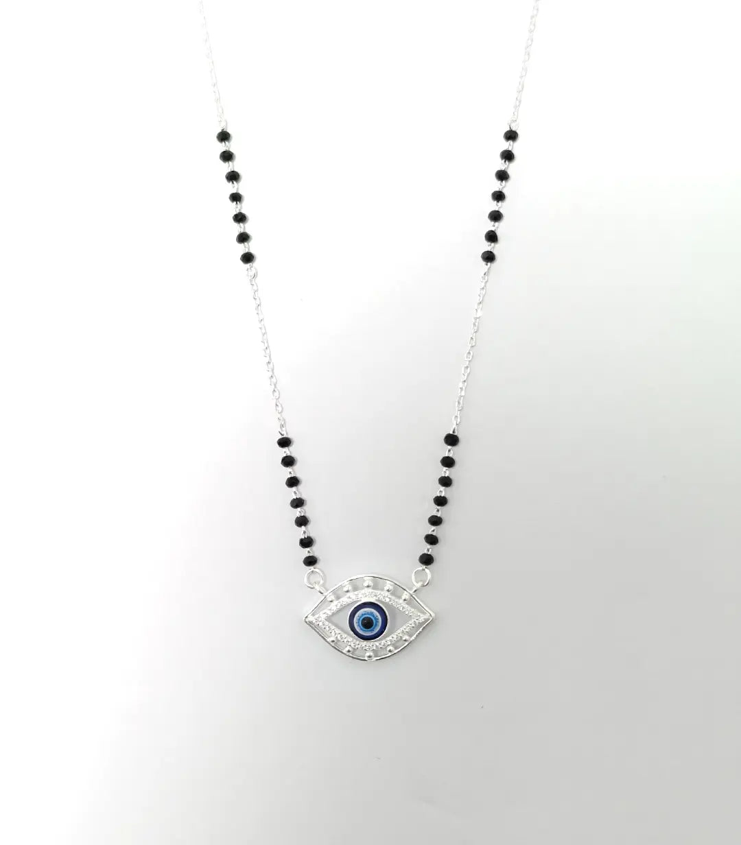 Necklace with eye-shaped pendant and black beads on a white background