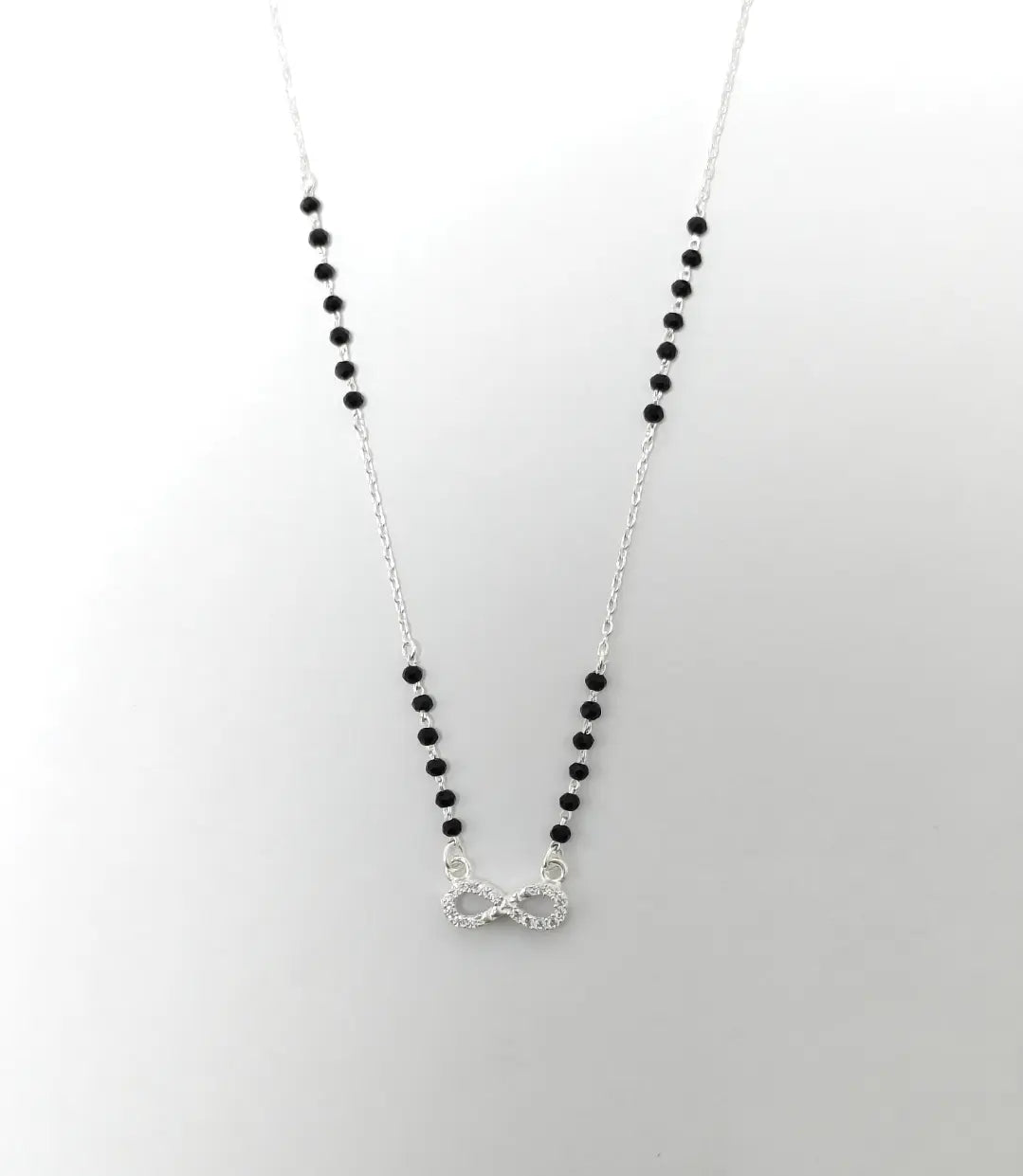 Necklace with black beads and a silver clasp on a white background