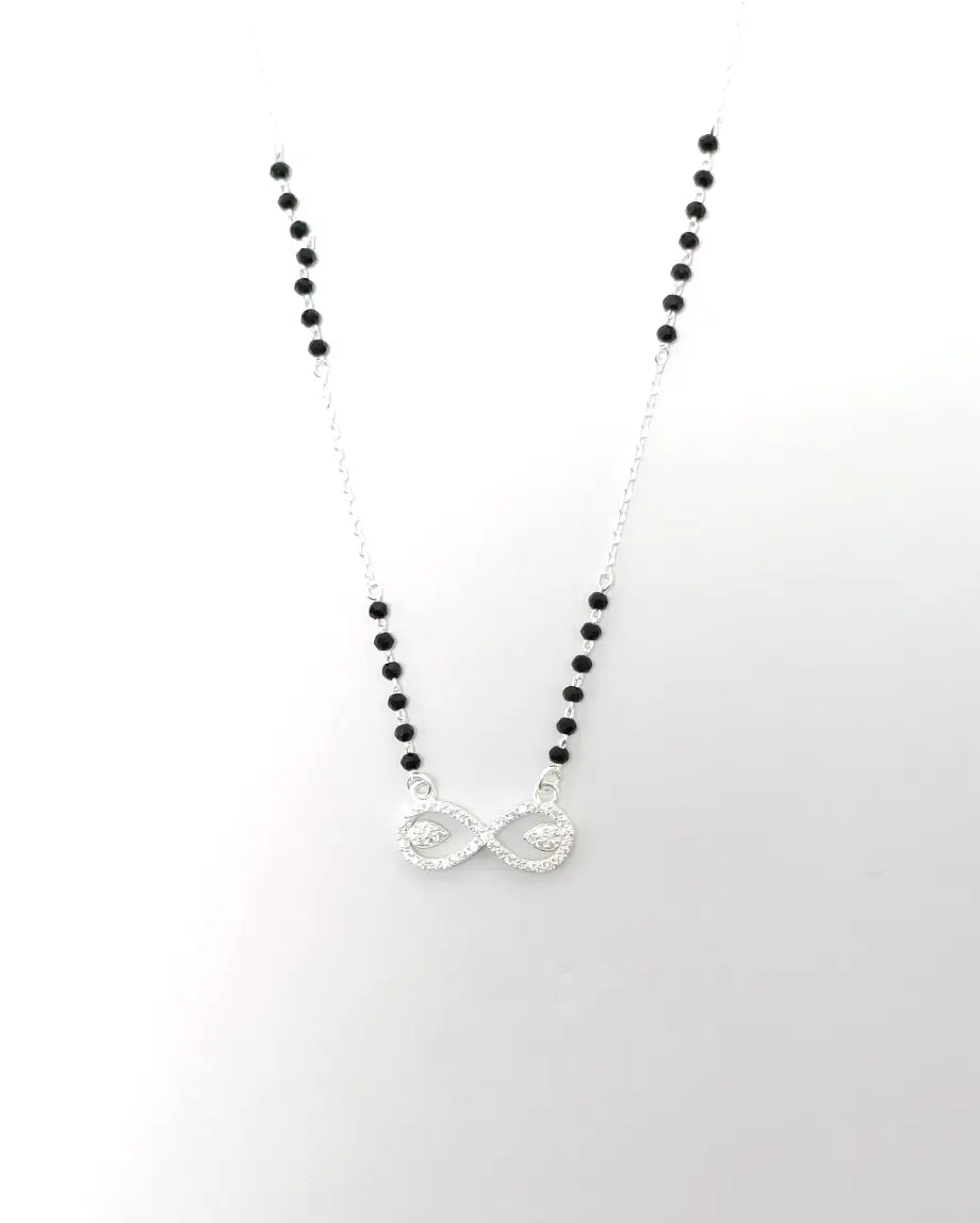 Necklace with black beads and a silver infinity symbol pendant on a white background