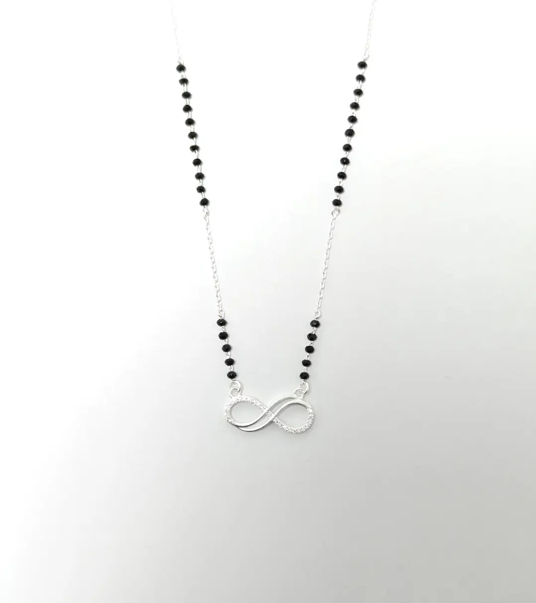 Necklace with black beads and a silver infinity symbol on a white background