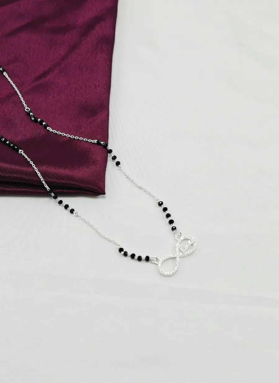 Necklace with black beads and a silver clasp on a white background