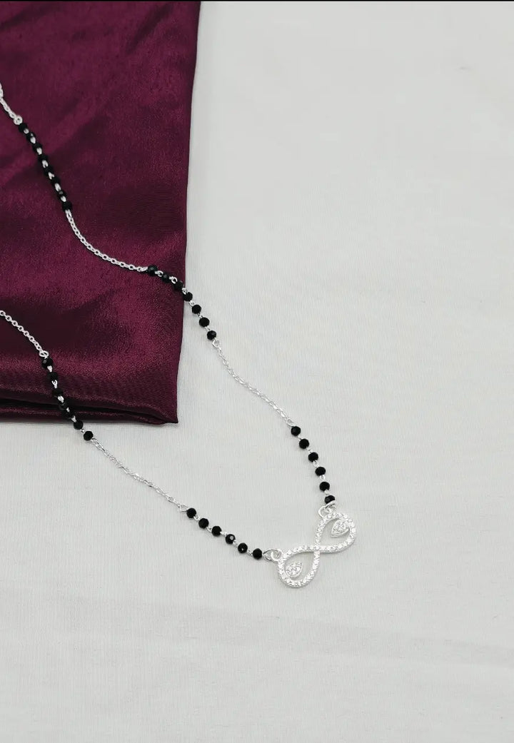 Necklace with black beads and a silver clasp on a white background