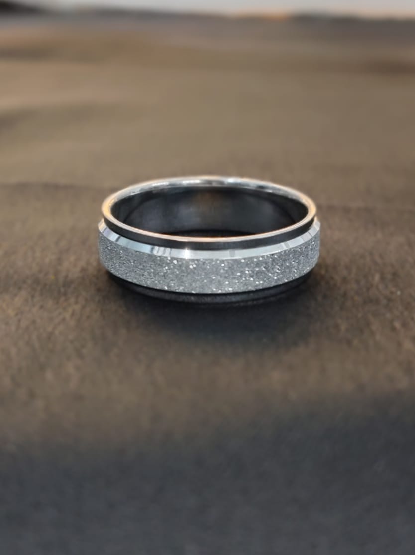 Ring with black and silver design on a wooden surface
